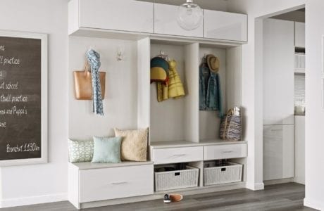 Mudroom storage in a white high gloss finish with extra drawers, hooks, cabinets by California Closets