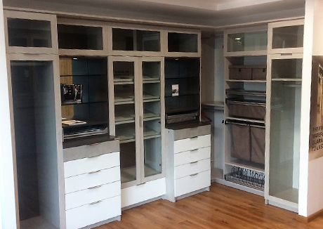 California Closets Guadalajara showroom interior multiple cubbies with and without clear glass doors open shelving clothing hanging spaces with and without clear glass doors and drawers.