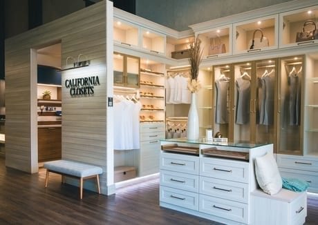 California Closets showroom interior with white island dresser, shelving with custom lighting and white cubbies