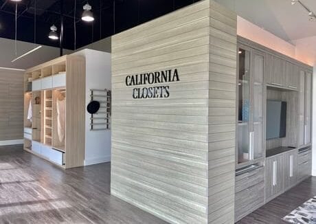 Light gray interior wall of showroom displaying California Closets logo