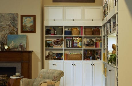 Family room storage in traditional white wood grain finish cabinets and shelves by California Closets