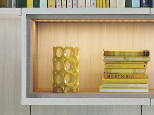 Close Up of Off White Library Shelf with Grey Trim Built in Lighting and Light Wood Backing