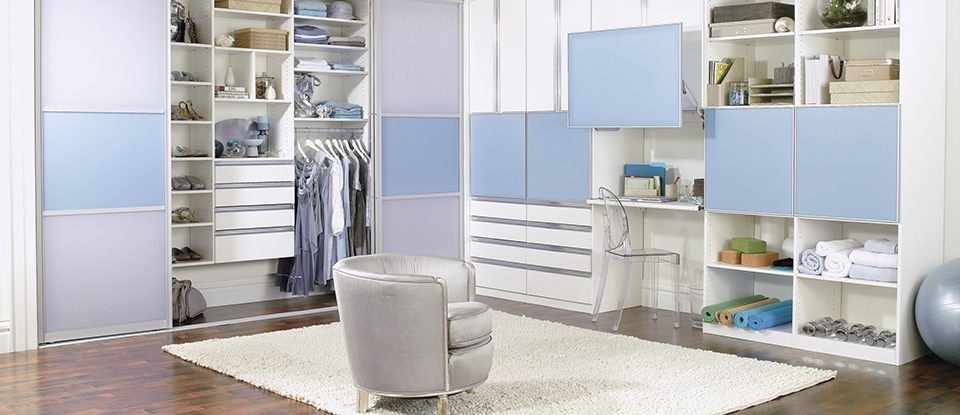 Office with an open reach in closet and exercise equipment with custom shelving, cabinets and drawers in cool summer colors by California Closets