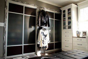 Walk in Closet with White Shelving Black and Metal Sliding Doors Cabinets with Glass Door and Black Stand Alone Seating Bench