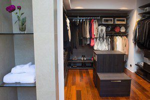 Dark Brown Walk in Closet with Shelving Closet Rods Floor Level Cubbies and Stand Alone Tiered Dresser