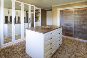 White Walkin Closet with Mirrored Wardrobe Doors Shelving with Frosted Glass Sliding Doors and Stand Alone Dresser with Dark Brown Wood Grain Top