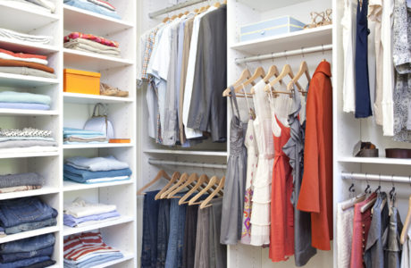 White walk in closet details with shelving for sweaters, shoes and accessories and extra racks for hanging clothes by California Closets