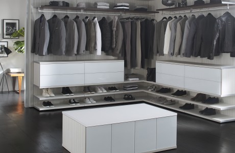 Modern closet in all white high gloss finish with light grey backing, open shelving, shoe storage and custom racks by California Closets