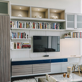 Entertainment Center with White Floating Shelving and Display Cubbies Dark Wood Cabinets and Dark Blue Drawers