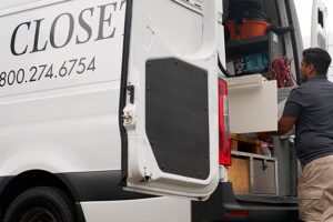 Técnico de instalación en el sitio de trabajo de instalación de armarios moviendo materiales de construcción de California Closets