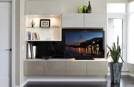White entertainment center with shelving cabinets built in lighting and high gloss grey accents.
