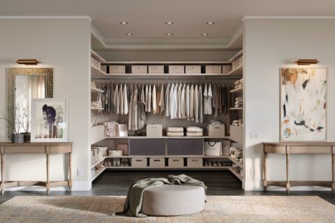 Diseño de vestidor en forma de U con acabado en madera veteada clara de California Closets
