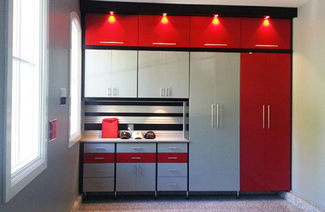 Garage storage cabinets in high gloss red and grey tool rack with built in lighting designed by California Closets