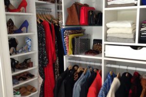Close Up Image of Walk in Closet with White Shelving and Closet Rods