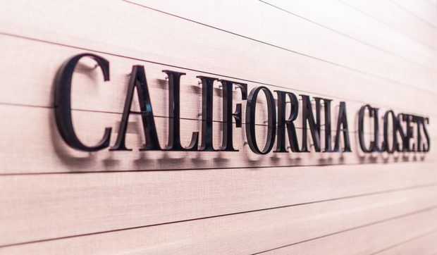 Metal California Closets logo on wood panel wall at Sayville Showroom