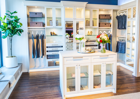 California Closets showroom in Sayville with mock walk-in closet with white island dresser in center surrounded by shelving