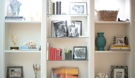 TV personality Charissa Thompson's classic white bookshelves displays photographs and trophies