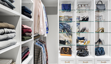 Glass box column shelving displaying colorful shoes and purses