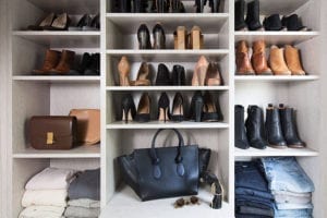 Shoes jeans shirts and accessories organized in light grey custom shelving