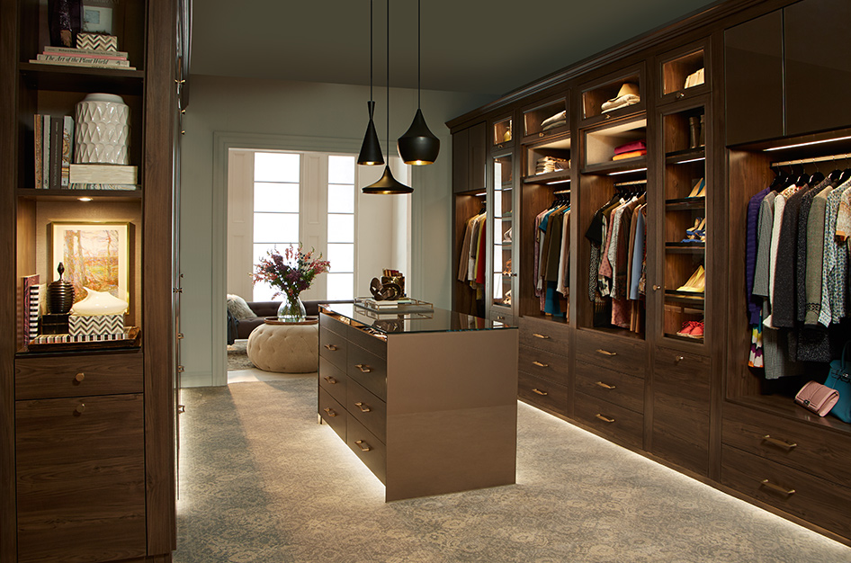 Sophisticated bedroom walk in closet by California Closets