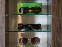 Trinh Vo Yezter Commercial Client Story Close Up of Glass Sunglass Shelving with Dark Brown Finish