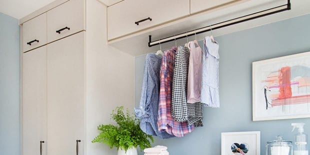 Light tan laundry room cabinetry with hanging pole to dry clothes