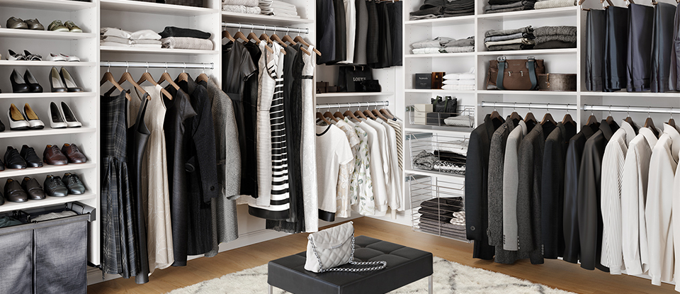 Black and white organized his and hers walk in closet by California Closets