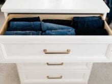 White drawers with gold handles fashion blogger Brittany Sjogren's walk in closet by California Closets