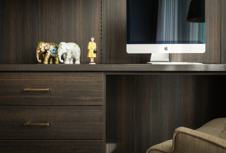 Dark wood home office desk with Apple computer and figurines