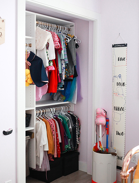White California Closets child's closet with two rows of hanging clothing in pink room