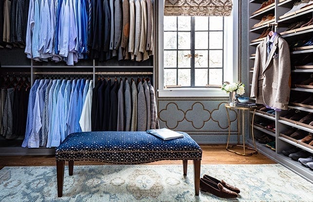 Walk-in closet with blue shirts and shoe shelving designed by Amber Colo and Sarah Smith