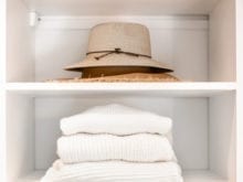 White shelving with hat and white towels