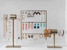Three jewelry holders covered in earrings, and bracelets