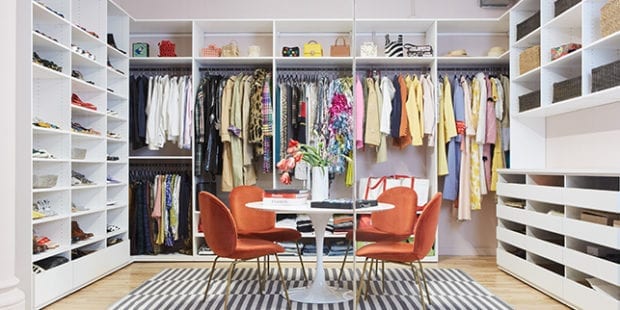 Custom closet with storage drawers, cabinets and hanging poles for clothing created by California Closets