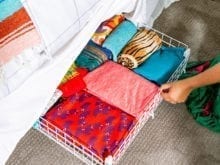 Pull-out wire rack with shirts under bed | California Closets