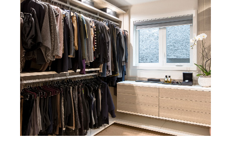 Clothes hanging on closet rods inside custom closet | California Closets