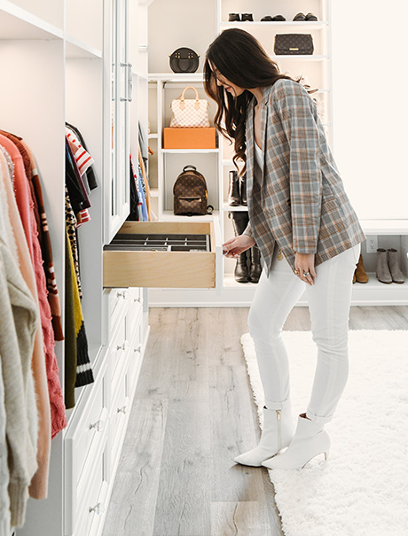 Vlogger Shea Whitney admiring the custom drawers in her walk- in closet by California Closets