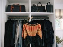 Organized clothes hanging and bags stored in shelves | California Closets