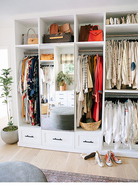 Custom closet hanging space and drawers for designer Emily Current, created by California Closets