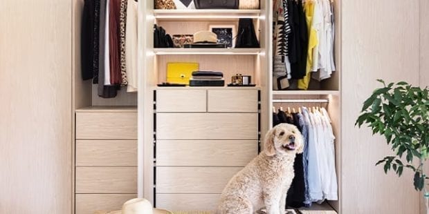 Cute dog sits in front of custom light tan reach in closet | California Closets