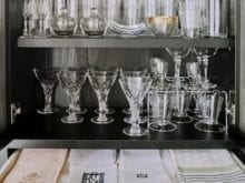Wine glasses arranged on black dining room shelves | California Closets
