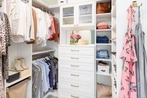 Influencer Kelly Natenshon's organized white walk-in closet with gold accents
