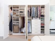 Influencer Kelly Natenshon and her husband's organized white reach-in closet with divider and hamper