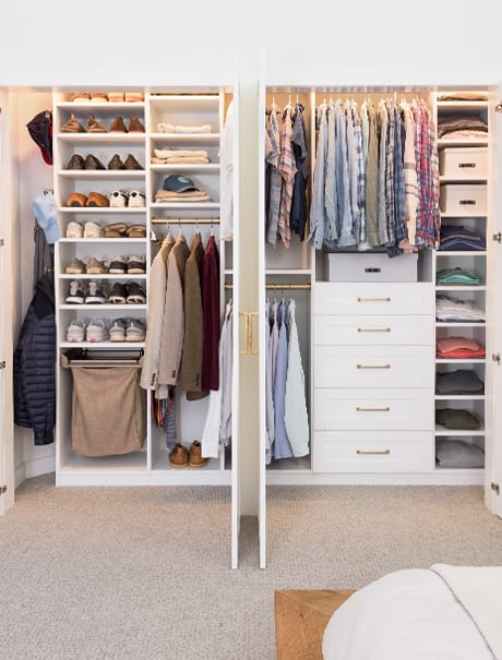 Influencer Kelly Natenshon and her husband's organized reach-in closet with a white finish