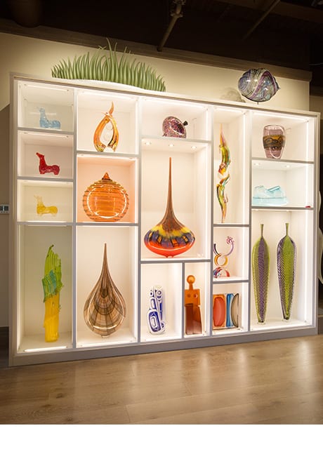 Full view of wall of colorful vases in lighted box shelves