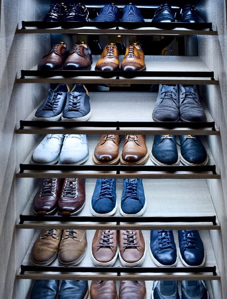 Rows of mens shoes organized on lighted shelves