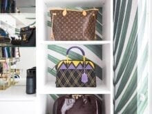 3 luxury handbags on display on white shelves