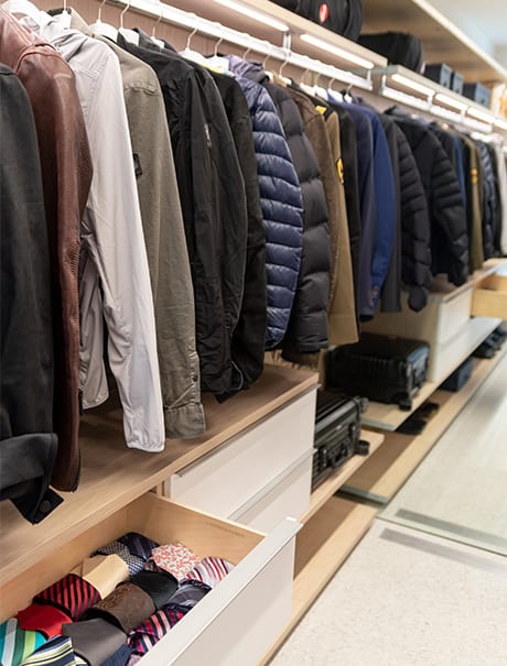 Hanging mens coats with accessories organized on shelves