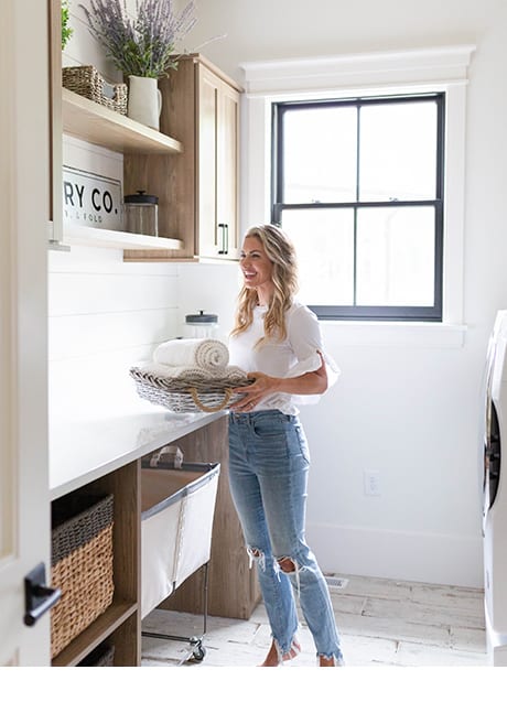 Eva Shockey in custom laundry room, farmhouse design with natural wood grain finish, baskets and shelving by California Closets