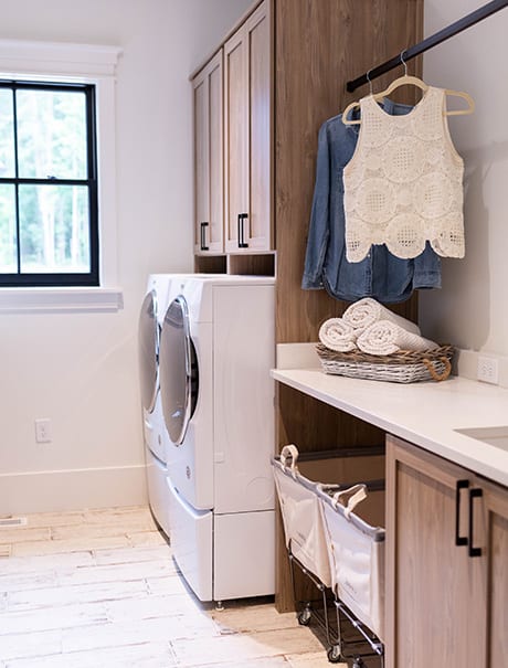 Laundry room with white washer, dryer and cabinet storage